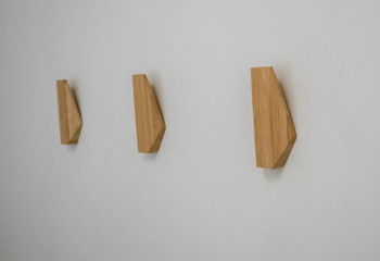 wooden abstract wall hook mounted against wall