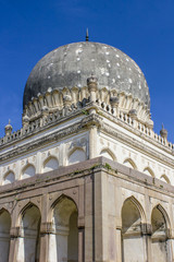 Fototapeta na wymiar Perspective Looking up from the Corner of One of the Tombs as Its Dome Reaches up into the Bright Blue Sky at the Qutb Shahi Tombs in Hyderabad, India