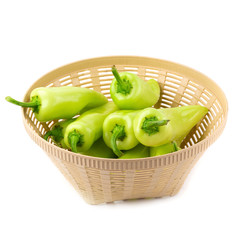 Green hot chili peppers in the basket isolated  on white background