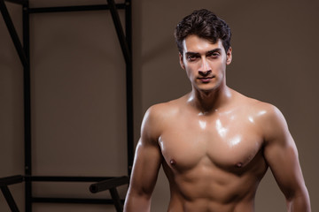 Ripped muscular man in gym doing sports