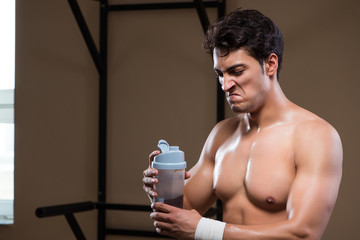 Man with nutrient supplements in sports gym