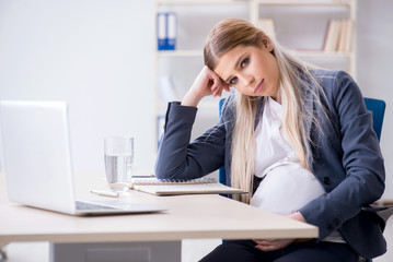 Pregnant woman employee in the office