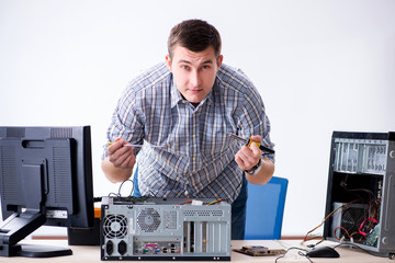 Young technician repairing computer in workshop