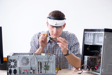 Young technician repairing computer in workshop