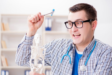 Medical student studying skeleton in classroom during lecture