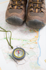 Fototapeta na wymiar Hiking boots and compass on map