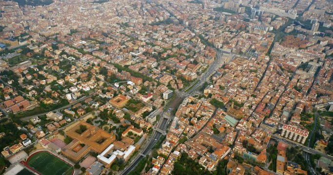 Flying above city of Barcelona buildings and streets, Spain. Aerial view
