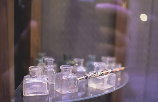 Ink pen on background of empty glass ink jars