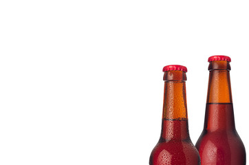 Red ale beer in bottles with water drops isolated on white background.