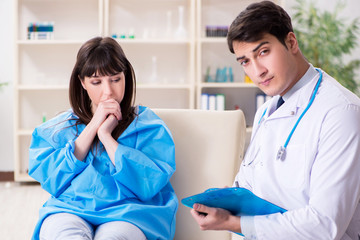 Male doctor checking up female patient in hospital