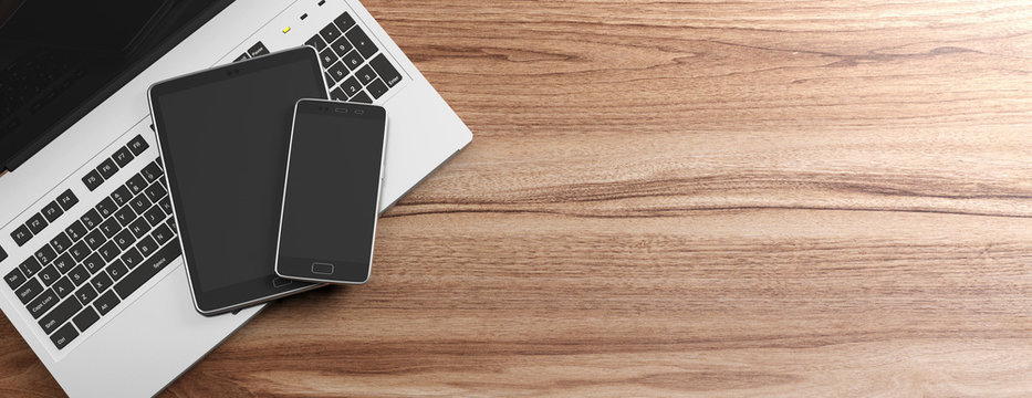 Mobile phone and tablet with blank black screens and a computer laptop on wooden background, copy space. 3d illustration