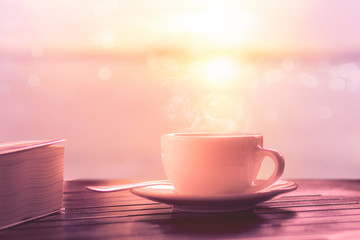 hot coffee on wooden table at sunrise