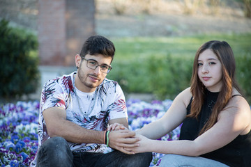 pareja sentada entre flores