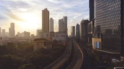 Fototapeta na wymiar Skyscrapers with highway overpass at sunrise time