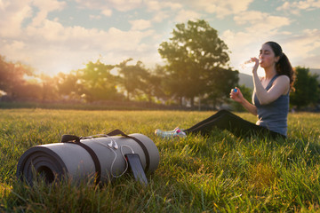 Mat for training with the phone lying on the grass on the background of athlet