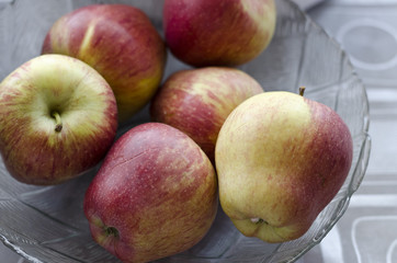 Apples in a glass plate on the table