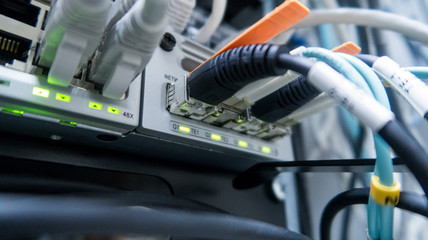 Network cables connected to switch - closeup of data center hardware. 