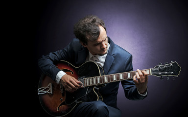 Lonely guitarist composing on cello with nothing around
