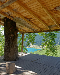 Fototapeta na wymiar view of blue water mountain lake from an old open shed