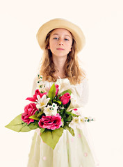 blond girl in white dress and straw hat with bouquet of flowers