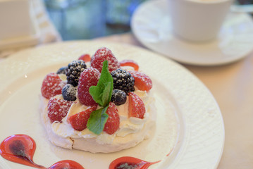 Pavlova cake with cream and berries