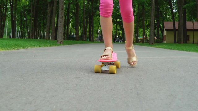 Young girl skateboarding on road in park. Legs on the skateboard, moves to success. teenager legs skating. leisure time