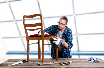 worker in blue  shirt repair old chair