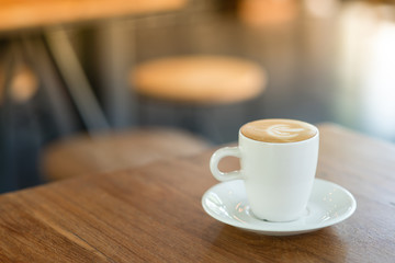 Obraz premium Hot Latte is placed on a wooden table in a cafe. Wait for customers to drink. To refresh the morning.