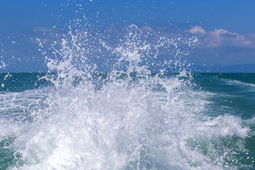 Blue ocean sea water wave with fast yacht boat wake foam of prop wash