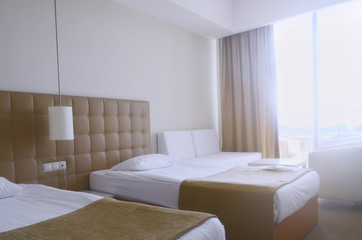 Sunny room in the hotel in light colors with two beds