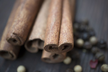 Pepper and cinnamon sticks on wooden table