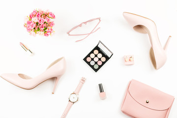 Fashion blogger workspace flat lay with pumps, cosmetics, purse, planner book and flowers.