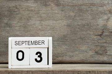 White block calendar present date 3 and month September on wood background