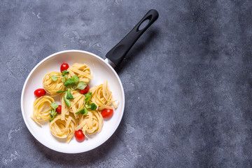 Raw Italian pasta with tomato in white ceramic pan