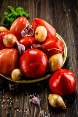 Tomatoes and onions on wooden background