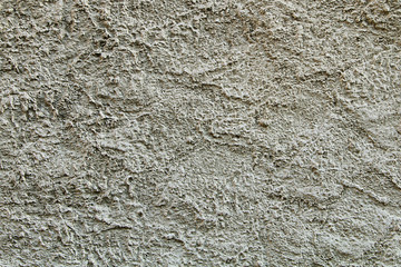 The texture of the stones and cobblestones. Fragment of a gray granite wall.
