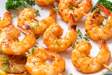 Grilled tiger shrimps skewers with lemon