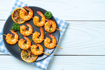 Grilled tiger shrimps skewers with lemon