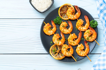 Grilled tiger shrimps skewers with lemon