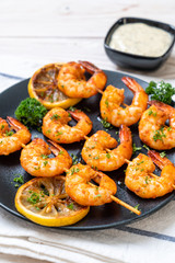 Grilled tiger shrimps skewers with lemon
