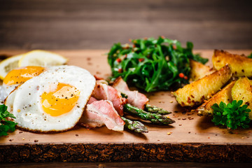 Asparagus with fried bacon and fried eggs