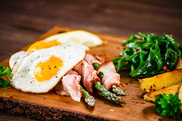 Asparagus with fried bacon and fried eggs