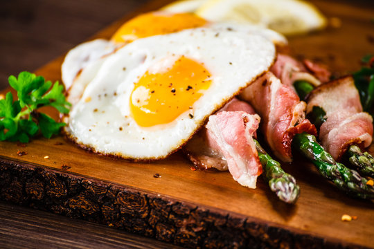 Asparagus with fried bacon and fried eggs