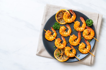Grilled tiger shrimps skewers with lemon