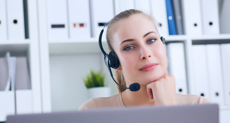 Close-up portrait of a customer service agent sitting at office.