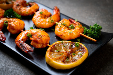 Grilled tiger shrimps skewers with lemon