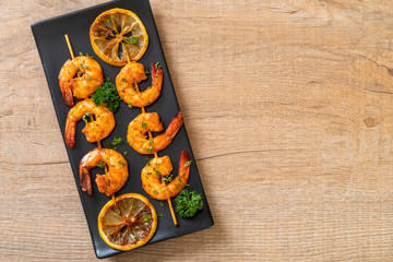 Grilled tiger shrimps skewers with lemon