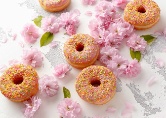 Sweet pink fresh Donut decorated with japanese Flowering Cherry Tree flower