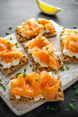 Homemade Crispbread toast with Smoked Salmon and soft chees, chives on white board