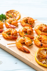 Grilled tiger shrimps skewers with lemon